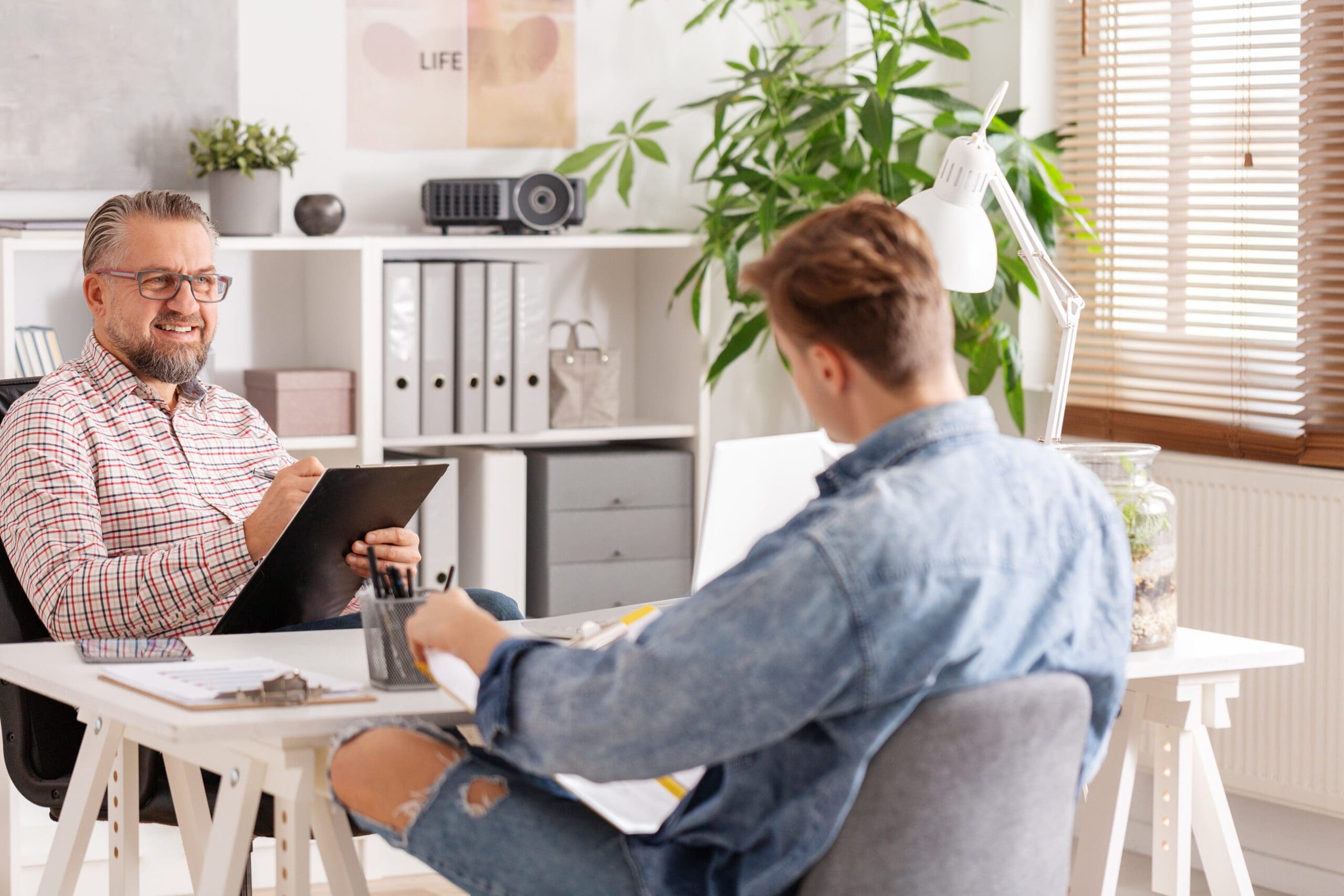 Young man with depression sitting in therapist's office